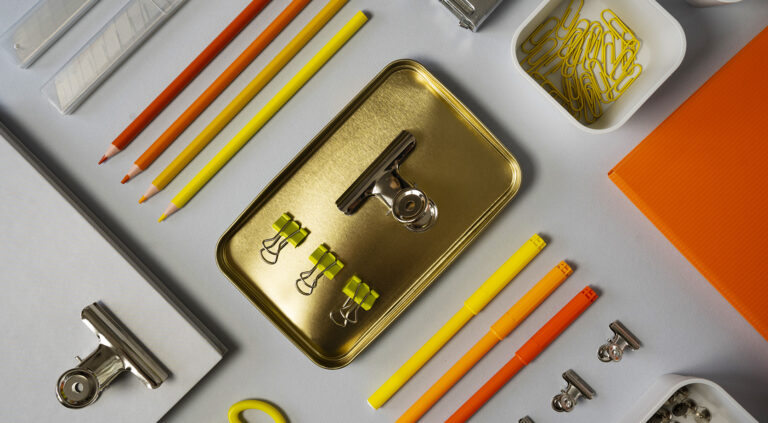 Sur un bureau, des outils de travail comme des pinces, des crayons et des feutres