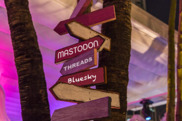 Panneaux avec les alternatives au réseau social X : mastodon, threads, bluesky