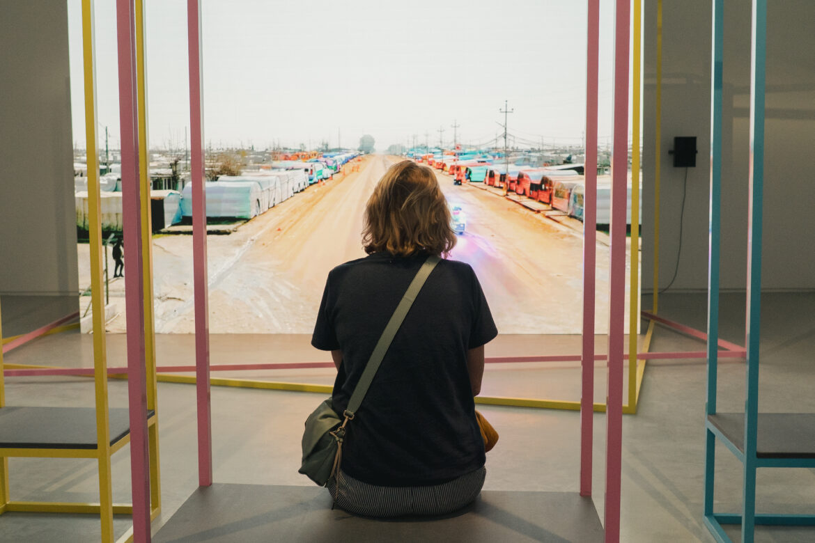 Une femme de dos regardant une oeuvre lors de l'exposition Le Monde selon l'IA - Jeu de Paume