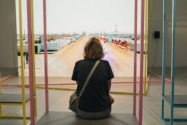 Une femme de dos regardant une oeuvre lors de l'exposition Le Monde selon l'IA - Jeu de Paume