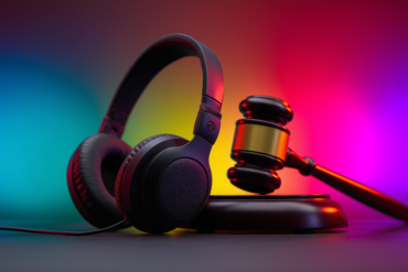 une paire d'écouteurs et un marteau de la justice, sur un fond coloré