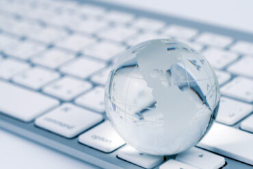 Un clavier d'ordinateur avec un globe en verre transparent
