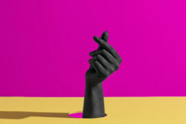 fond coloré, jaune et mauve, avec une main, peinte en noir qui sort du décor