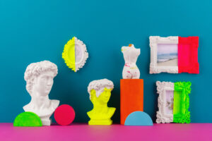 statues grecques peintes en partie dans des couleurs fluo, sur un fond bleu